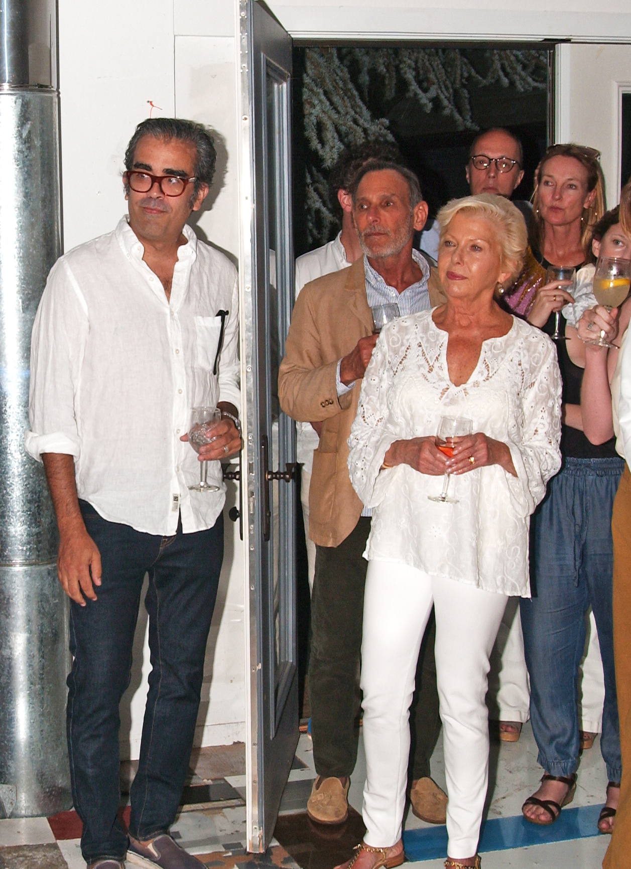 Artist Enoc Perez and David Salle in center of doorway among guests attend an event in celebration of Eric's forthcoming exhibition at the Dallas Contemporary at the former home and studio of artist Elaine de Kooing, East Hampton, NY.